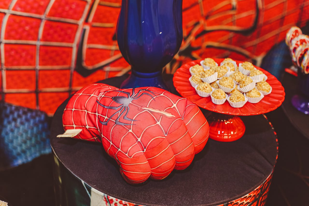 Vibrant Spider-Man themed glove and desserts on a decorative tray for a lively food presentation.